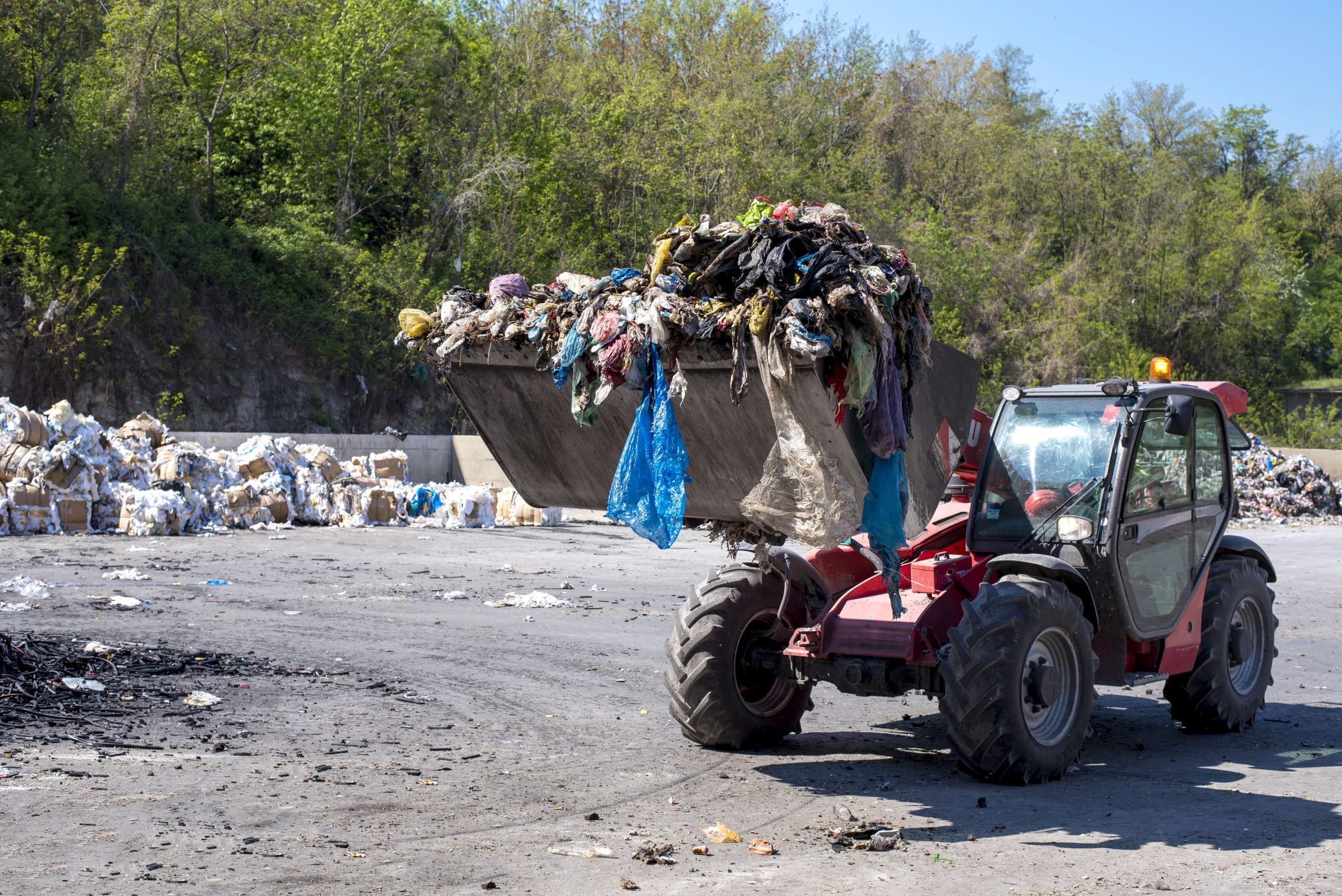 Wheel loader moving municipal waste at a treatment plant