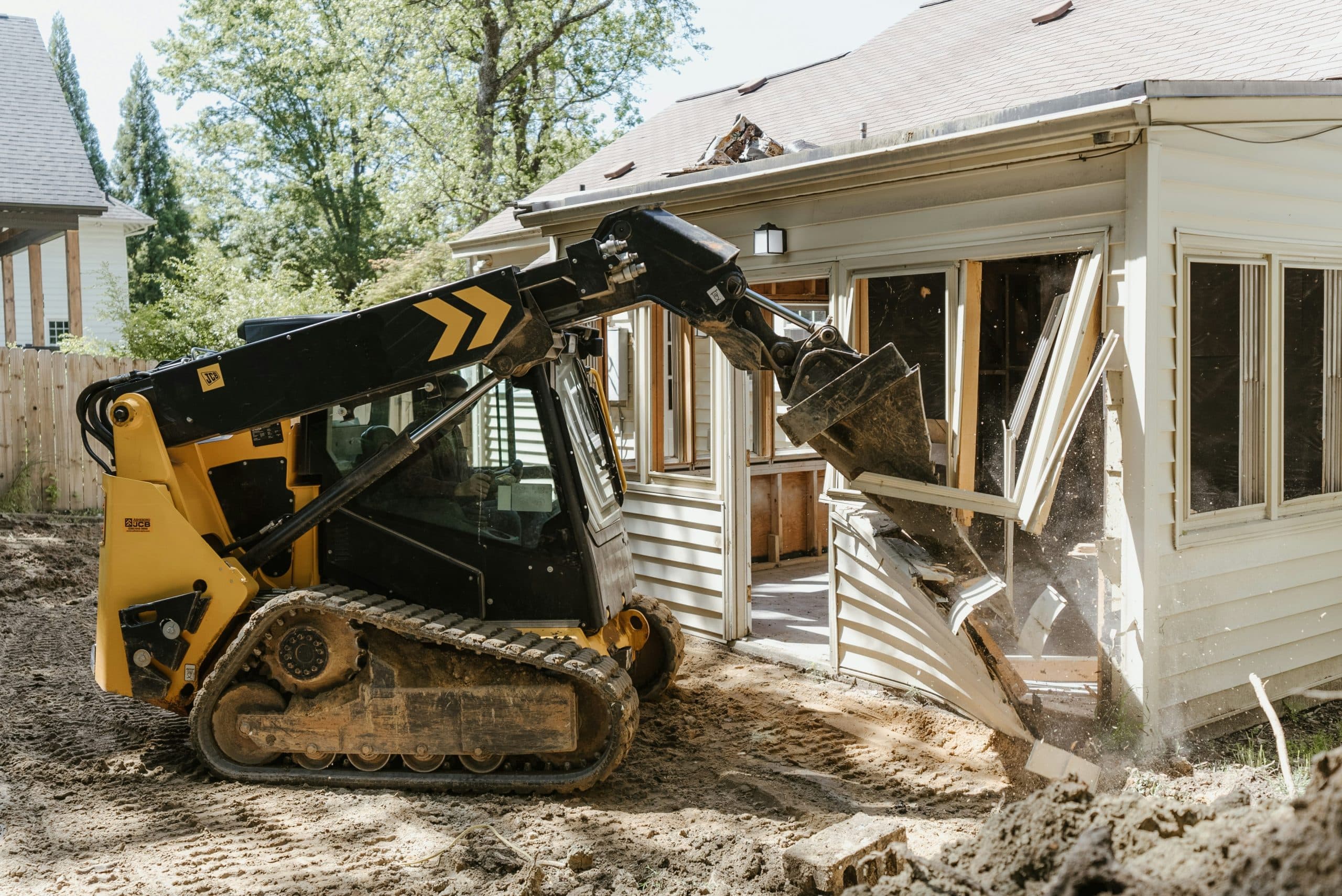 Excavator digging into a debris pile